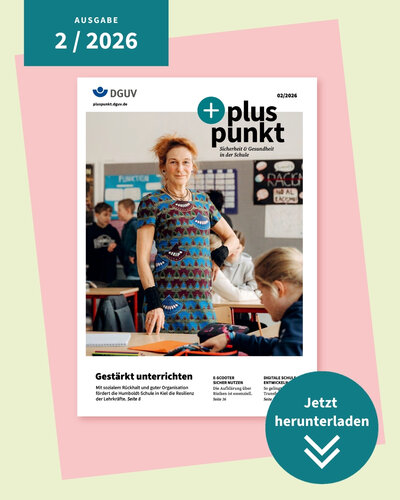 Eine Frau steht im Klassenraum vor einem Tisch